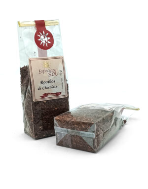Two clear plastic tea bags of chocolate rooibos tea, one standing and one lying, with a red-gold label reading Especias del SOL