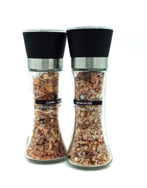 Pair of clear glass spice grinders with black tops and metal bands, filled with pinkish-brown flakes and labeled Iberico Mix.