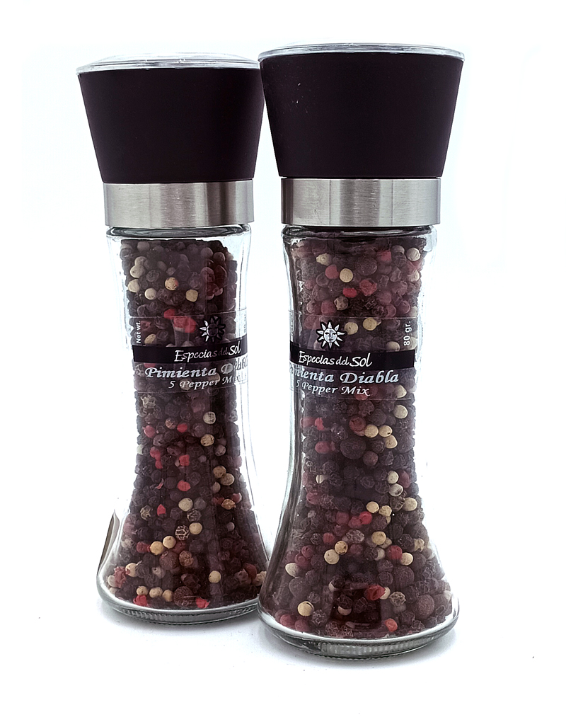 1776794963811b - El Gourmext de Casa Chino Pair of clear glass pepper mills with black tops, filled with multicolored peppercorns on a white background.