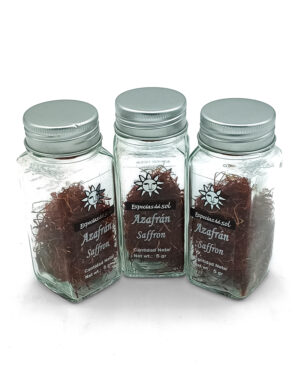 Three glass spice jars with silver lids contain saffron, labeled Azafrán Saffron with a sun logo.