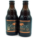 1777484624813 - El Gourmext de Casa Chino Two dark beer bottles with copper labels standing side by side on a white background.