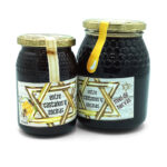 1777484624914 - El Gourmext de Casa Chino Two glass jars of dark honey with hexagonal-patterned gold lids and labels reading 'entre castaños y encinas' on a white background.