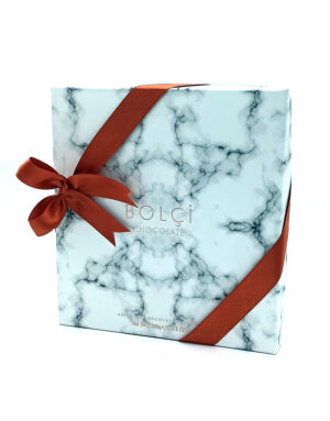 Marble-pattern blue gift box with a red ribbon tied in a bow and ‘BOLCI CHOCOLATE’ logo on the front (308g).] ,