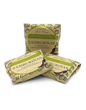 Three packets of Doña Tomasa Zamburiñas in olive oil with garlic and chili, beige packaging with green labels (limited edition).