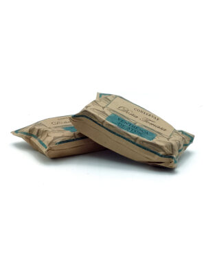 Two brown paper-wrapped food packages stacked on a white surface, blue labels visible