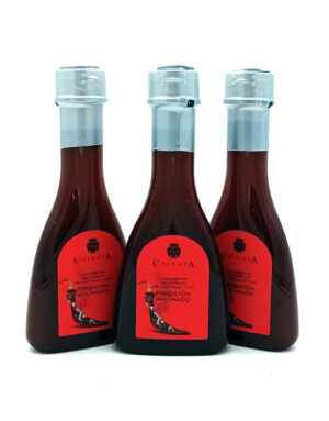 Three bottles of smoked paprika sauce with red labels and blue-tinted caps, arranged in a row on a white background, brand Chinata.