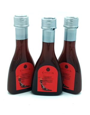 Three bottles of Chinata smoked paprika sauce with red labels and light-blue caps, arranged on a white background.