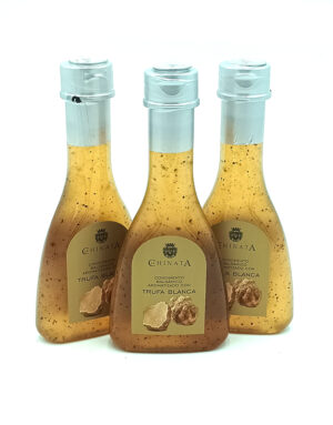Three glass bottles of truffle white balsamic sauce with pale blue caps, arranged in a row, front labels read 'Hinata Trufa Blanca'.