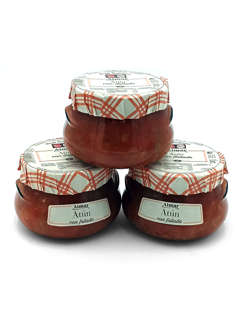 1777484625411 - El Gourmext de Casa Chino Four jars of tuna con fritada stacked in a pyramid, with cloth-covered lids and vintage labels visible