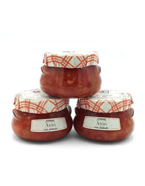 Three glass jars of tuna labeled 'Atún con fritada' with red plaid cloth lids, stacked on a white background.