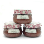 Three glass jars of Aimar Calamares en salsa española stacked in a pyramid, with pink plaid-covered lids.