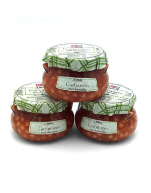 Three glass jars of garbanzos con bacalao stacked in a pyramid, with green checkered lids and white labels