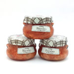 1777484625690 - El Gourmext de Casa Chino Three glass jars of Bacalao cod in tomato sauce with plaid metal lids, arranged in a pyramid on a white background.