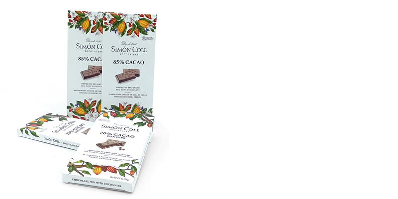 Assorted Simon Coll chocolate bars with white packaging and colorful botanical illustrations, showing 85% cacao and 70% cacao.
