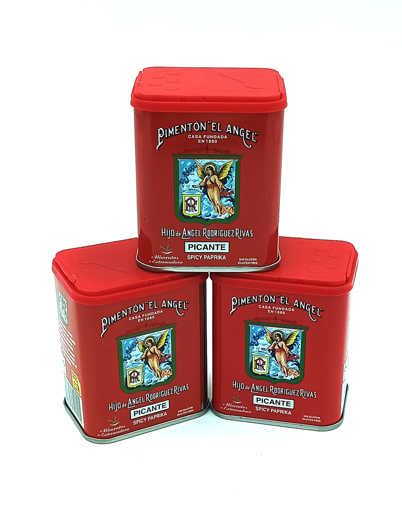 1778794820378 - El Gourmext de Casa Chino Three red spice tins labeled 'Pimentón El Ángel' (Picante, Spicy Paprika) stacked together in a triangular arrangement.