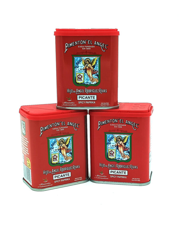 Three red tin cans of Pimentón El Ángel spicy paprika stacked in a pyramid, each with an angel crest label.