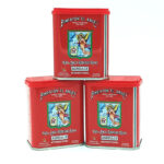 Three red metal tins of Pimentón 'El Ángel' stacked together, featuring an angel emblem and 'AGRIDULCE' on the front label.
