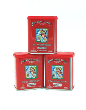 Three red metal tins of Pimentón 'El Ángel' stacked together, featuring an angel emblem and 'AGRIDULCE' on the front label.