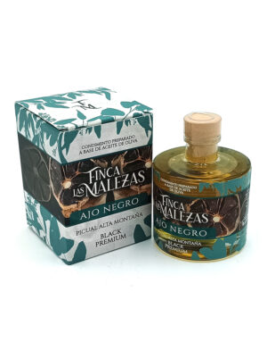Bottle of Finca Malezas Ajo Negro Black Premium garlic alongside its teal-patterned box featuring leaf designs and Spanish labeling.