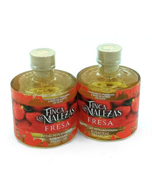 1776794962860 - El Gourmext de Casa Chino Two glass bottles of Finca Las Malezas Fresa strawberry oil side by side with red labels and cap seals visible.