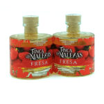 Two glass bottles labeled Finca Las Malezas Fresa premium strawberry olive oil, standing side by side on a white background with cork stoppers.