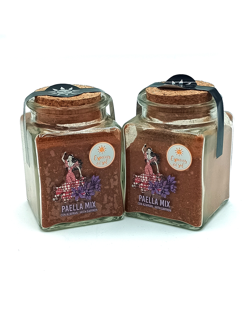 1776794963911 - El Gourmext de Casa Chino Two glass jars with cork lids containing paella mix labeled 'Paella Mix with saffron' beside decorative flowers on the label