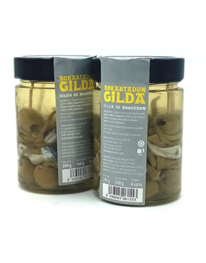 1777484622831 - El Gourmext de Casa Chino Two glass jars with black lids labeled Gilda de boquerón, containing marinated anchovy skewers in oil.
