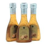 Three glass bottles of truffle white balsamic vinegar with beige labels on a white background.