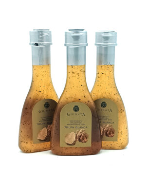 Three glass bottles of truffle white balsamic vinegar with beige labels on a white background.
