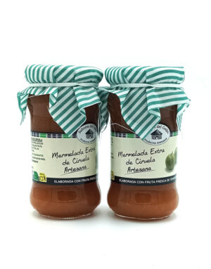 1778794818258 - El Gourmext de Casa Chino Two jars of artisanal plum jam with green-and-white striped cloth lids and beige labels.
