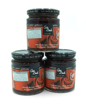 1778794818289 - El Gourmext de Casa Chino Three Can Bech rose-petal jam jars stacked—two on the bottom and one on top, with dark glass and red labels.