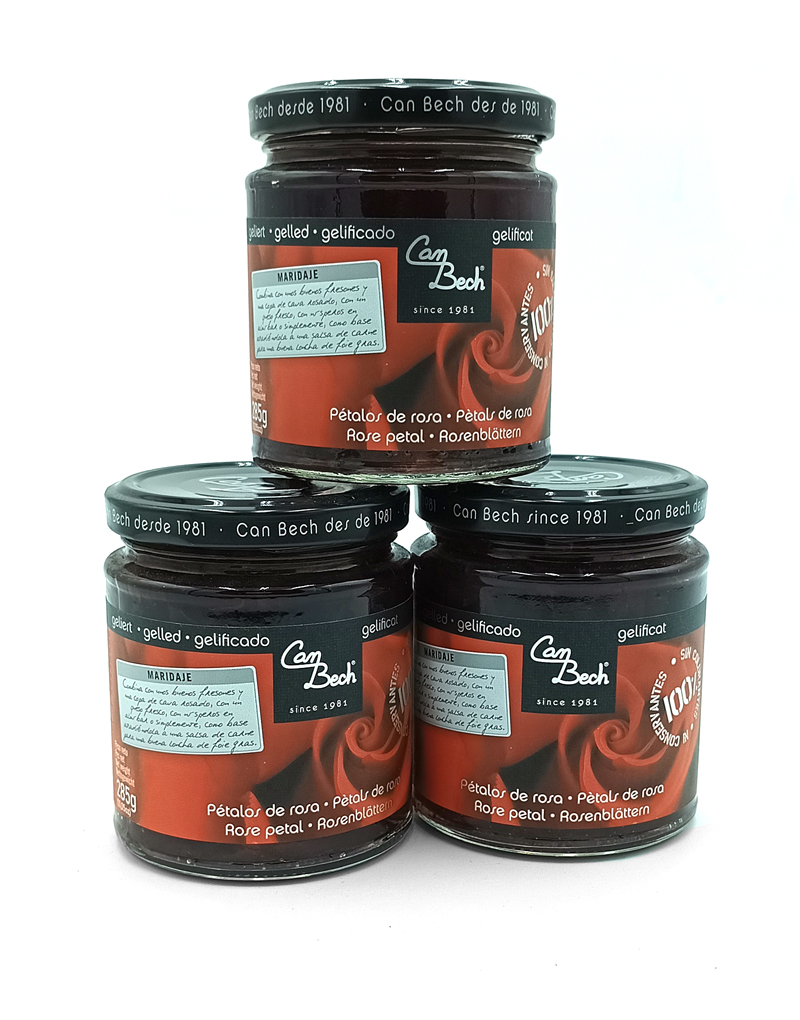 1778794818289 - El Gourmext de Casa Chino Three Can Bech rose-petal jam jars stacked—two on the bottom and one on top, with dark glass and red labels.