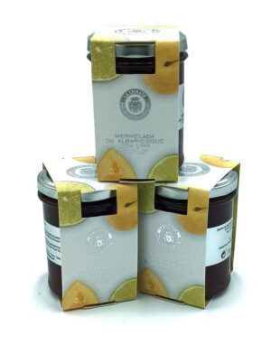 Three stacked boxes of marmalade packaging perched on top of three glass jars with lemon-lime imagery on the labels (product display).