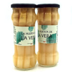 1778794819009 - El Gourmext de Casa Chino Two glass jars of white asparagus standing side by side with dark lids and light teal labels reading 'La Huerta de La Vera' on a white background.