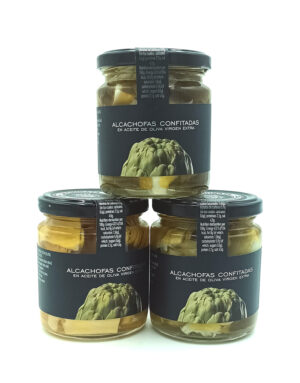 1778794819231 - El Gourmext de Casa Chino Three glass jars of artichokes confit in extra virgin olive oil on a white background, labels visible on each jar.