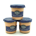 1778794819727 - El Gourmext de Casa Chino Three glass jars of Paté de Bonito tuna pâté from Conservas Emilia with blue foil lids, arranged in a small pyramid on a white background.