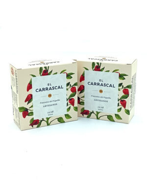 1778794820317 - El Gourmext de Casa Chino Two beige boxes with red chili illustrations and a blue label that reads 'EL CARRASCAL Pimientos del Piquillo ARTESANOS'.