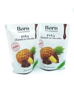 1778794820593 - El Gourmext de Casa Chino Two white standing pouches labeled Born Piña chocolate-covered dried pineapple treats, shown with pineapple and chocolate pieces on the front.